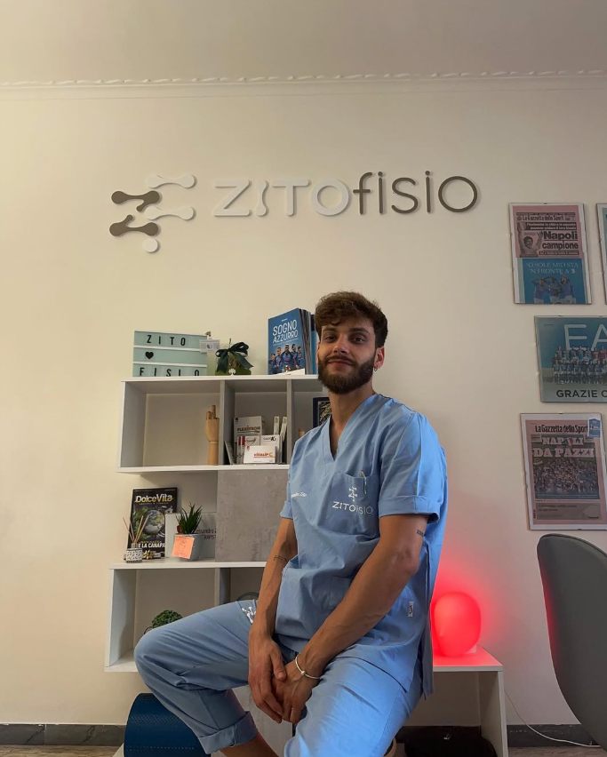 Il Dott. Alessandro Zito nel suo studio, davanti al logo ZITOFISIO